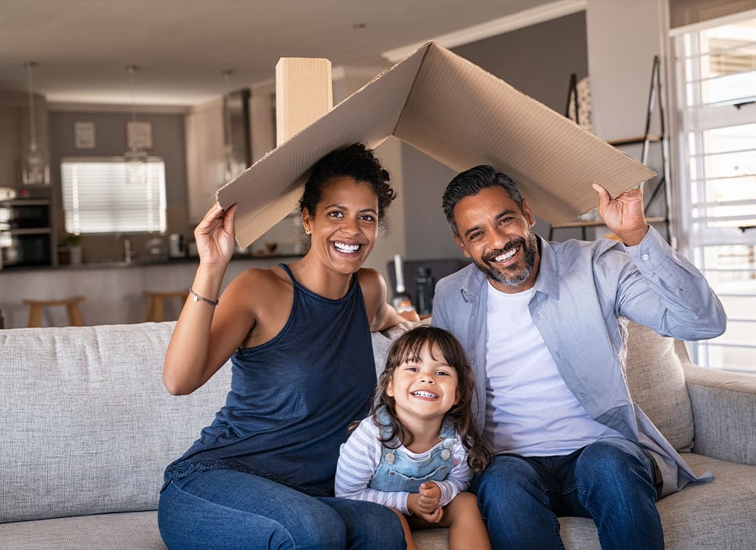 Personal Insurance - Family Posing For a Picture at Home While Sitting on Their Sofa